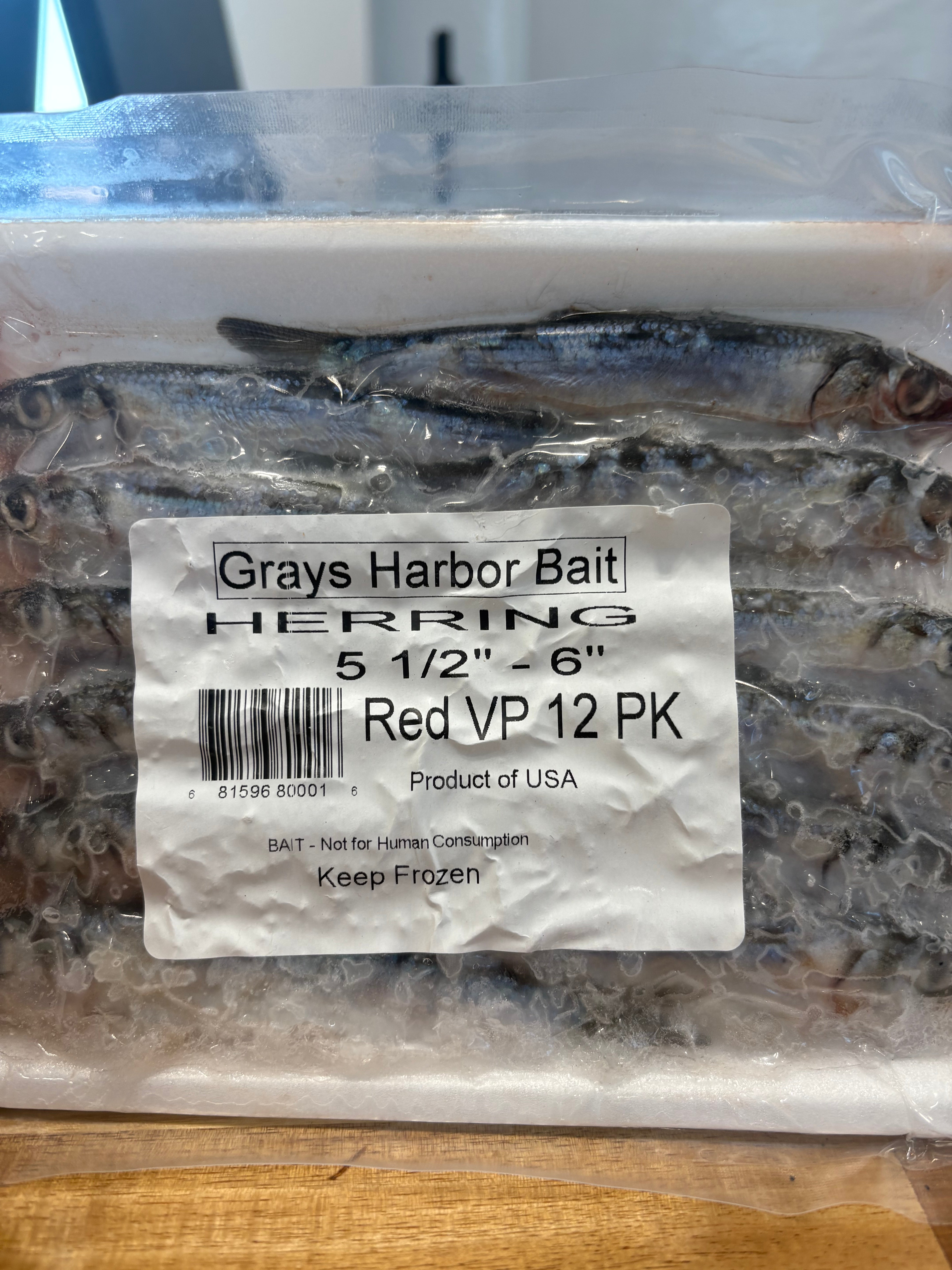 Packaged herring with Grays Harbor Bait label on a wooden surface